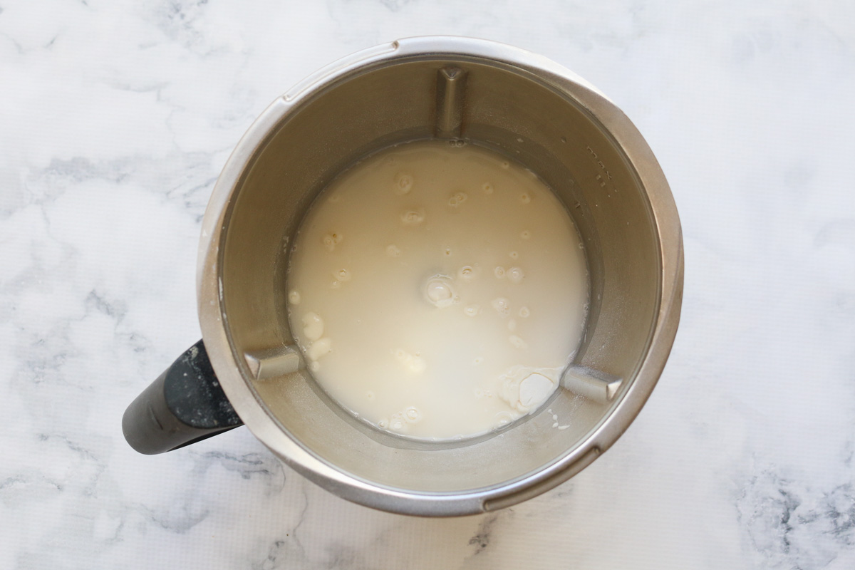 Agua, harina, sal y masa madre en un bol Thermomix.