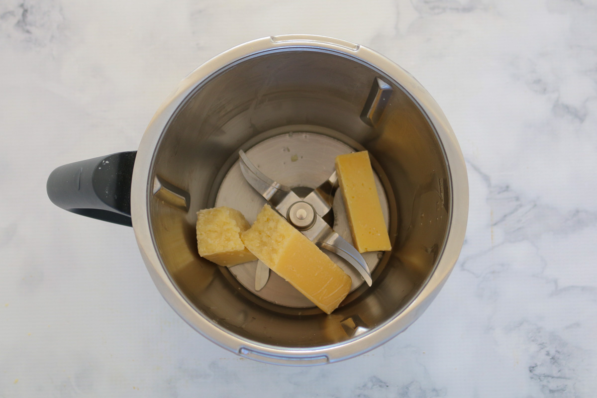 Trozos de queso parmesano en un bol Thermomix.