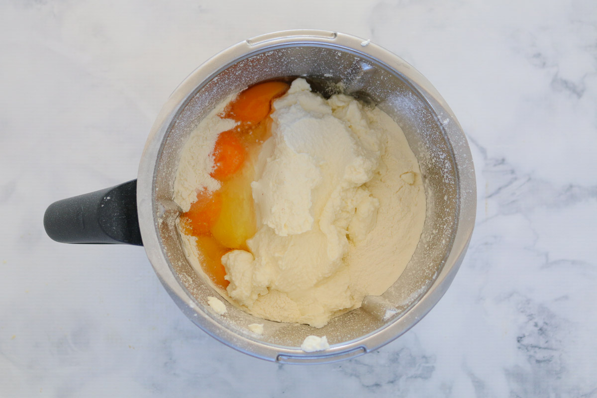 Huevos, parmesano, ricotta y harina en un bol Thermomix.