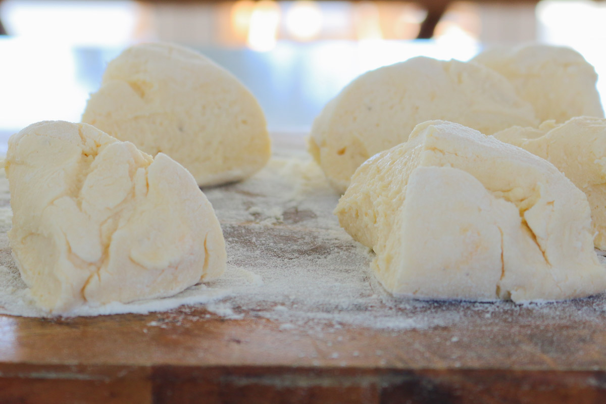 Masa de ricotta dividida en secciones sobre una tabla.