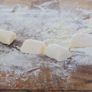 Homemade gnocchi on a floured wooden board.