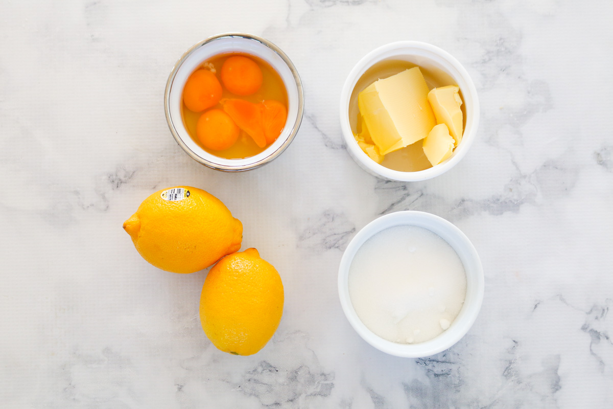 Mantequilla, azúcar, limones y huevos en cuencos.