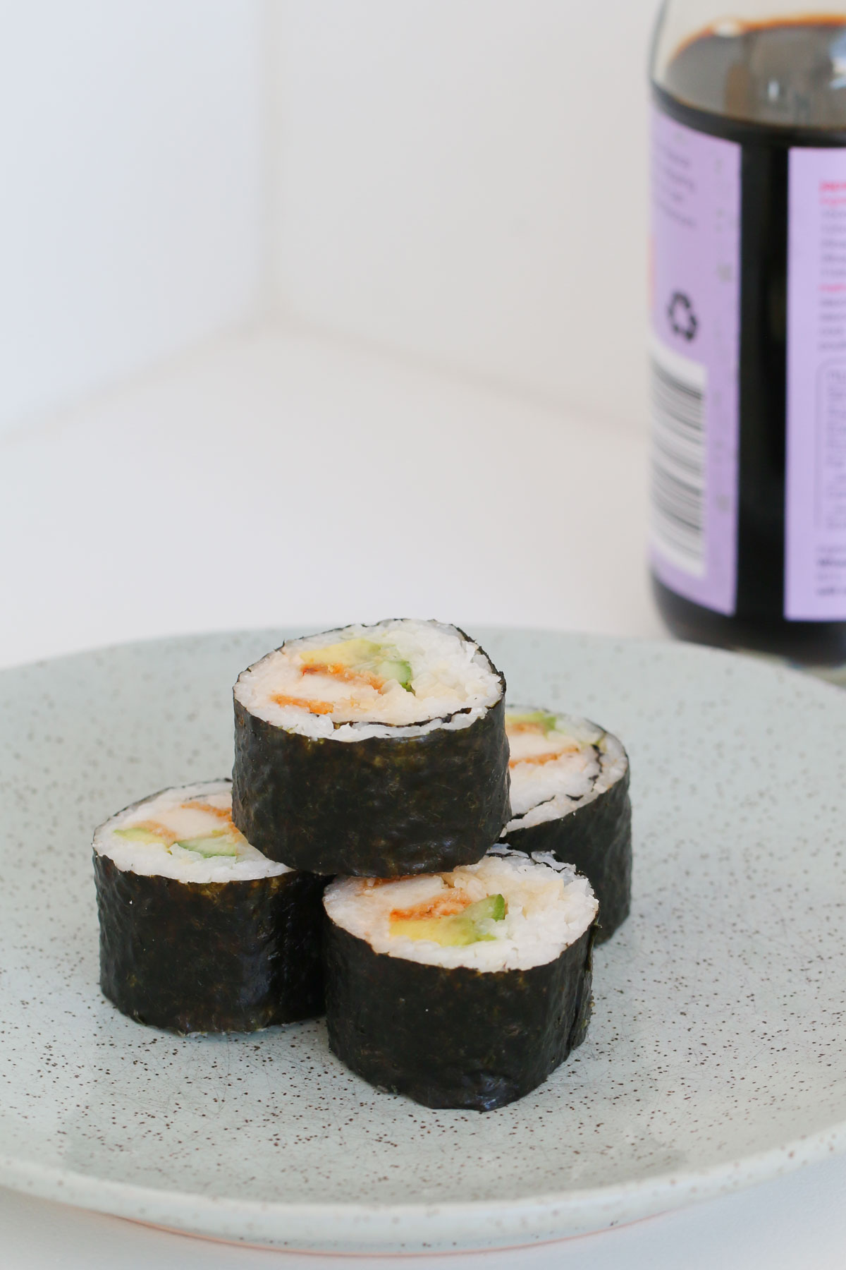 Sushi Thermomix casero con una botella de salsa de soja de fondo.