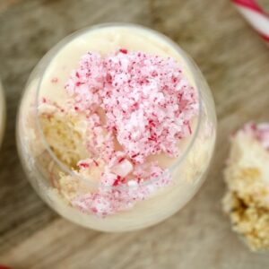 A glass jar of cheesecake with crushed candy canes.